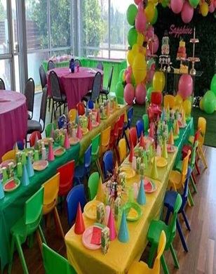 Colourful kids' party table and chair setup with balloon decor