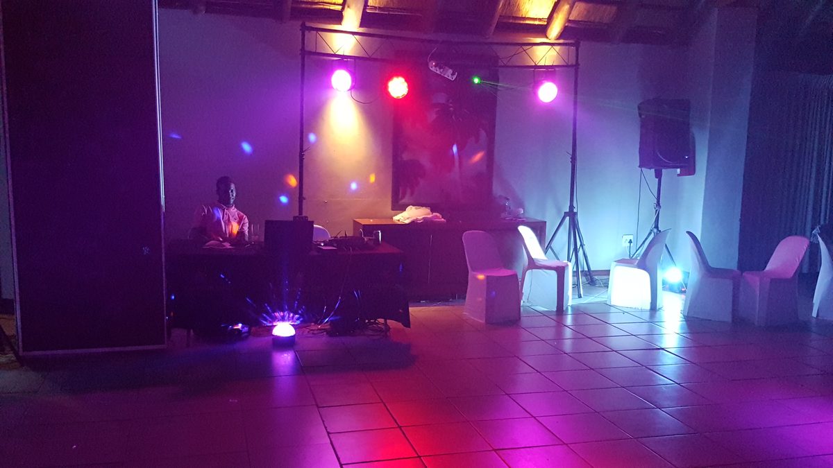 Indoor dance floor with stage lights, speakers and coloured wash lighting