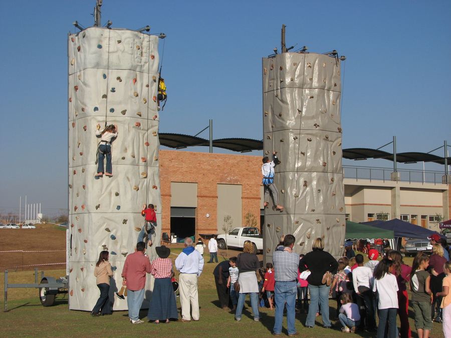 Participants scaling a mobile climbing wall during a team building event