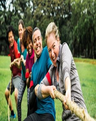 Team building group taking part in a tug of war activity outdoors