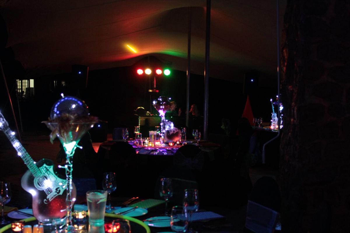 Stretch tent set up with lit centrepieces and DJ lighting for a year-end function
