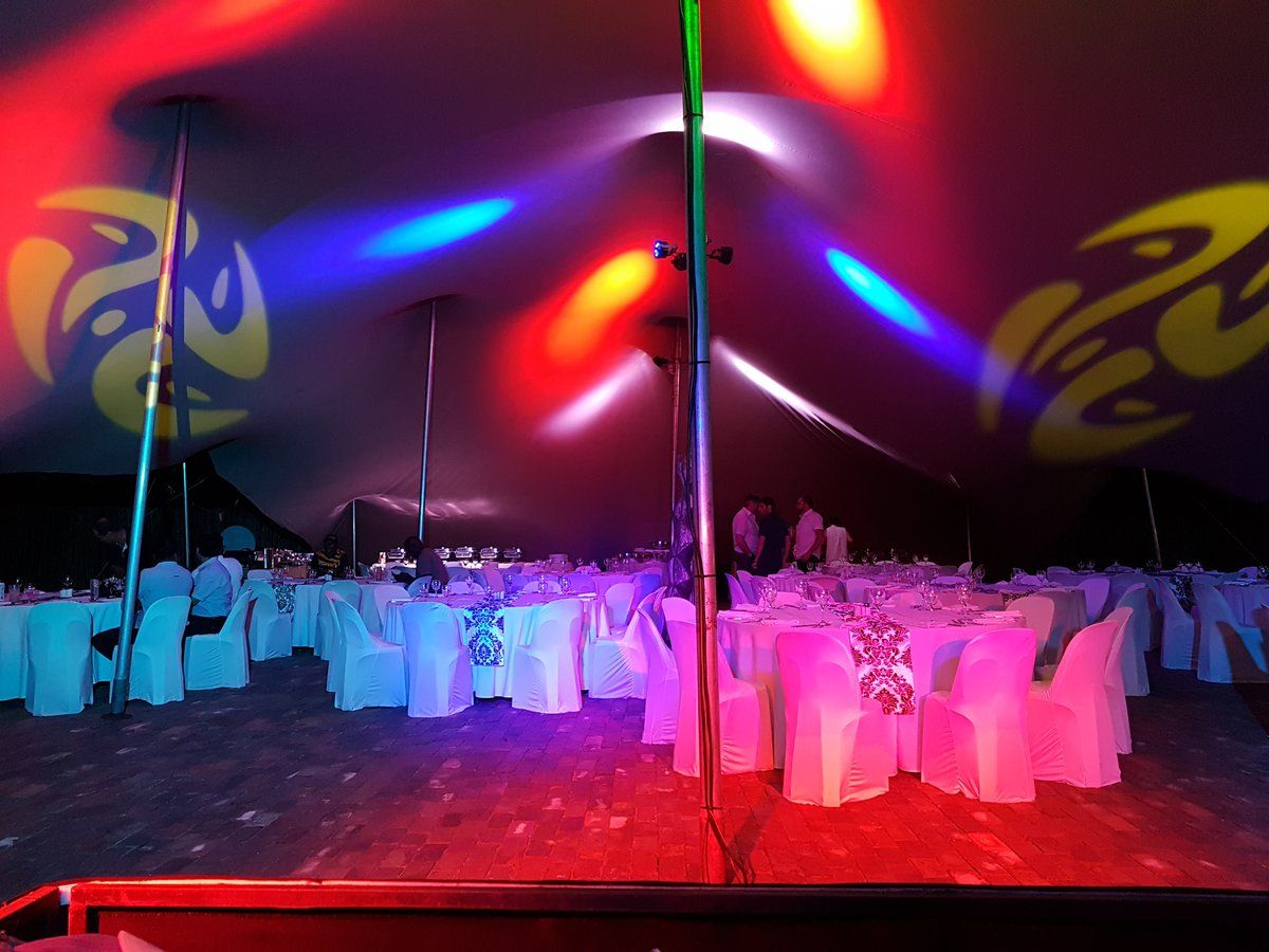 Year-end gala dinner under a stretch tent with colourful lighting