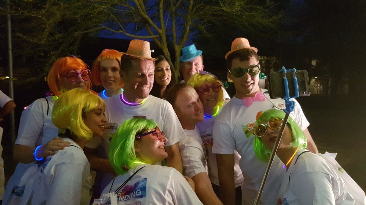 Colleagues in colourful wigs and hats at a themed year-end party